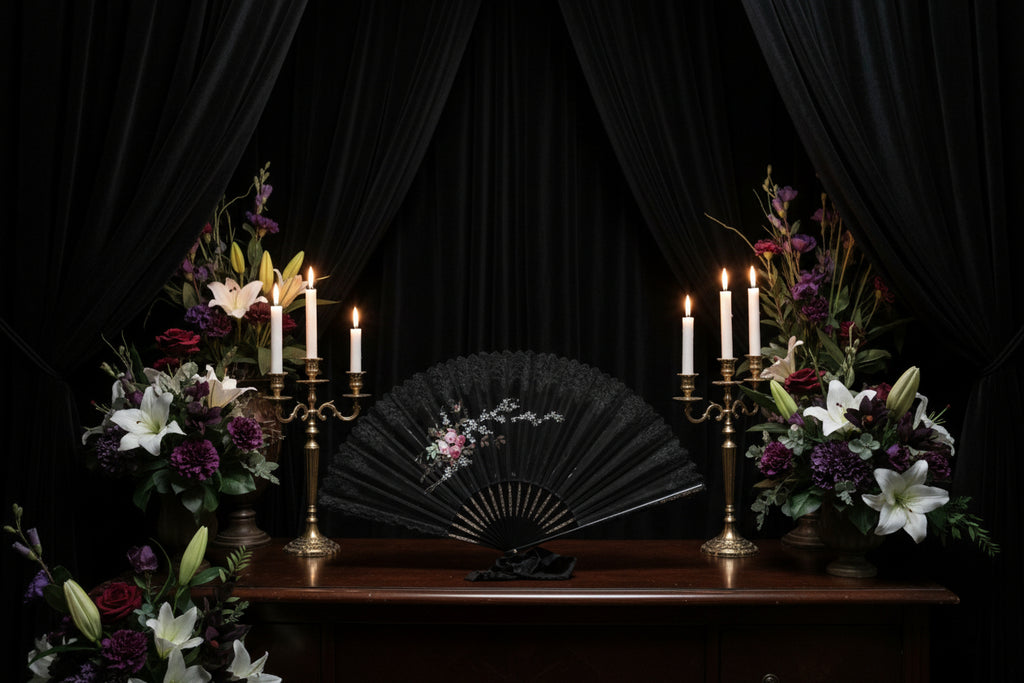 Decorative black fan with floral design on a white surface